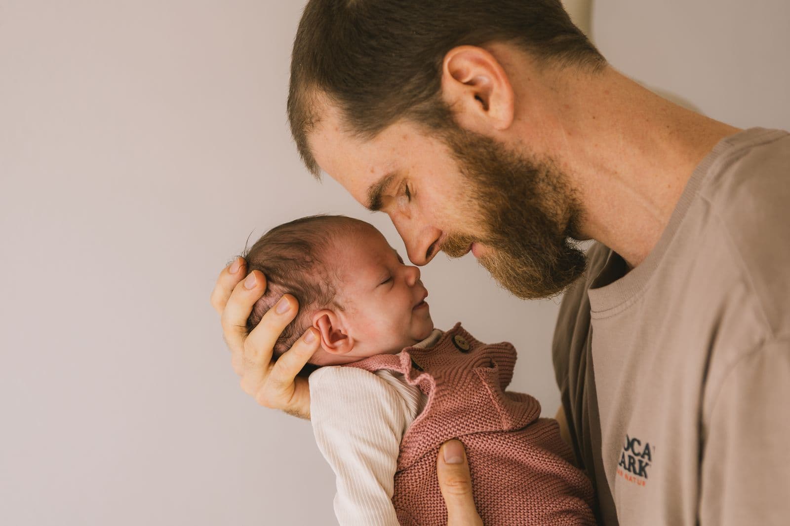 Papa und Neugeborenes Stirn an Stirn