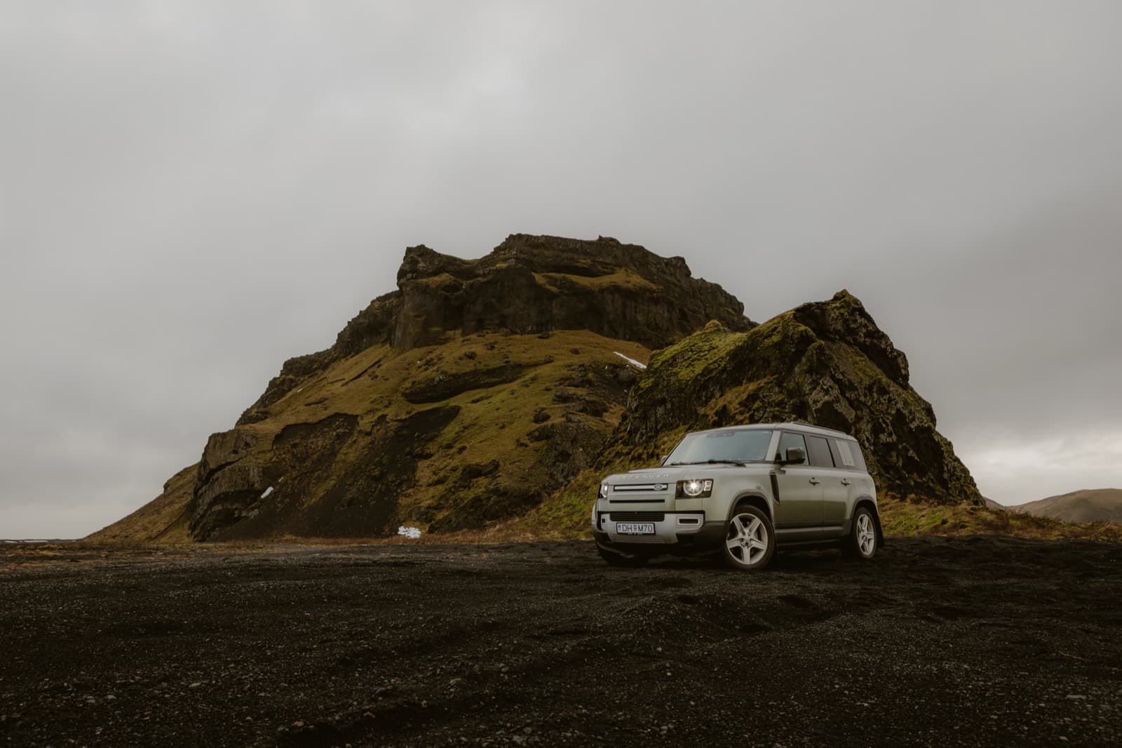 Defender vor dramatischer Felslandschaft